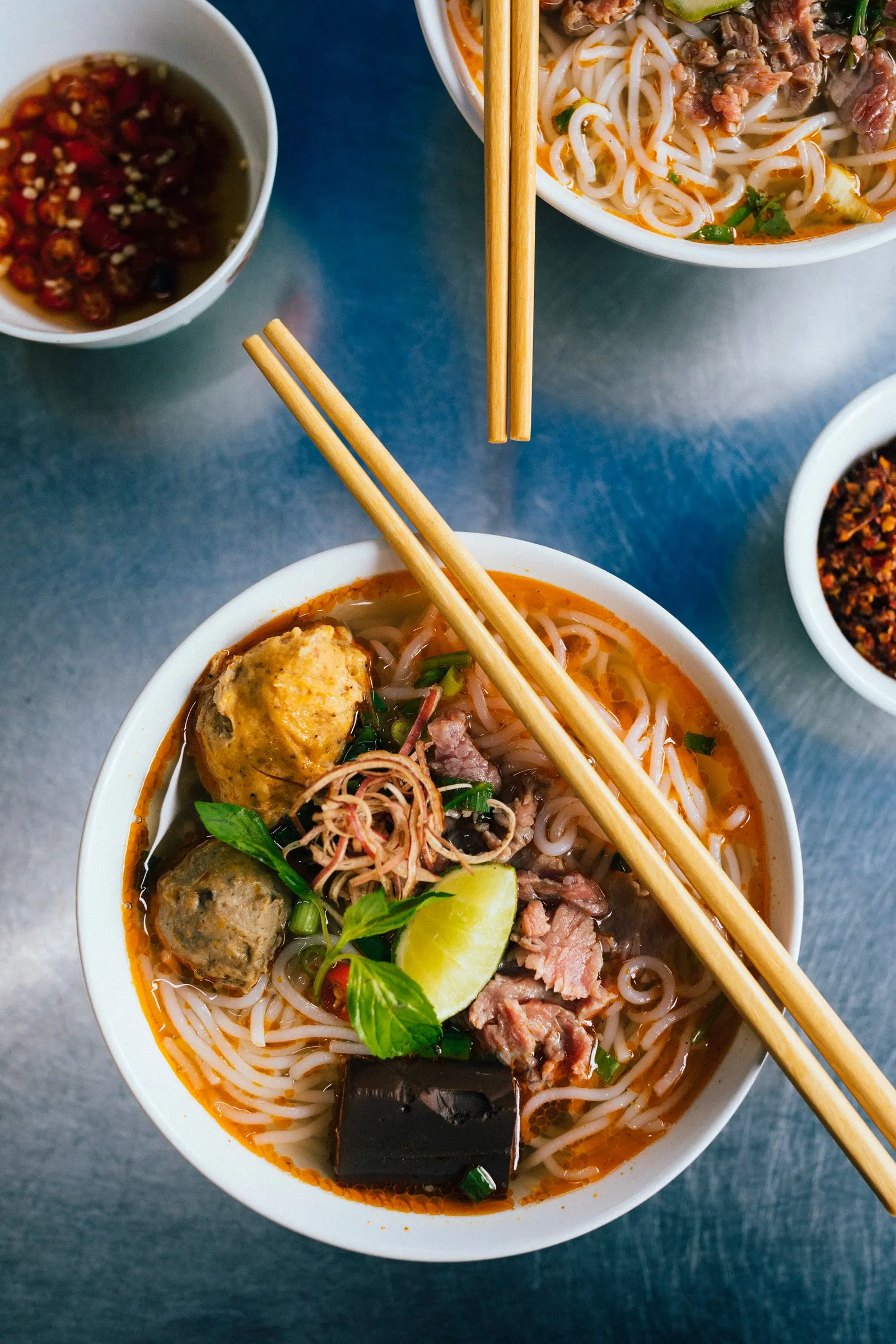 Bowl of bún bò Huế with beef and fresh herbs