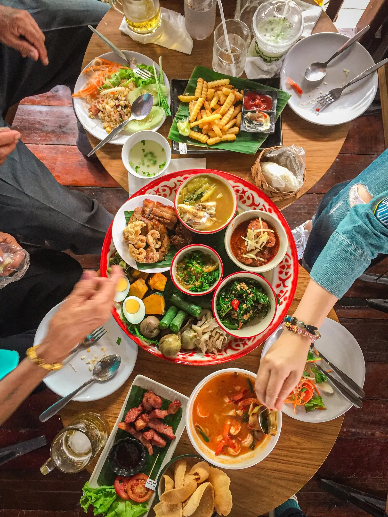 Guests sharing a table full of Vietnamese and Thai dishes