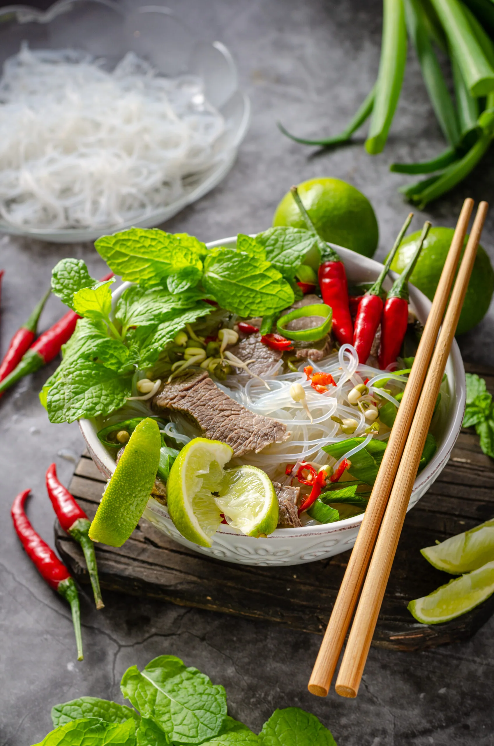Traditional Vietnamese soup with chilli, noodles, fresh herbs and beef meat
