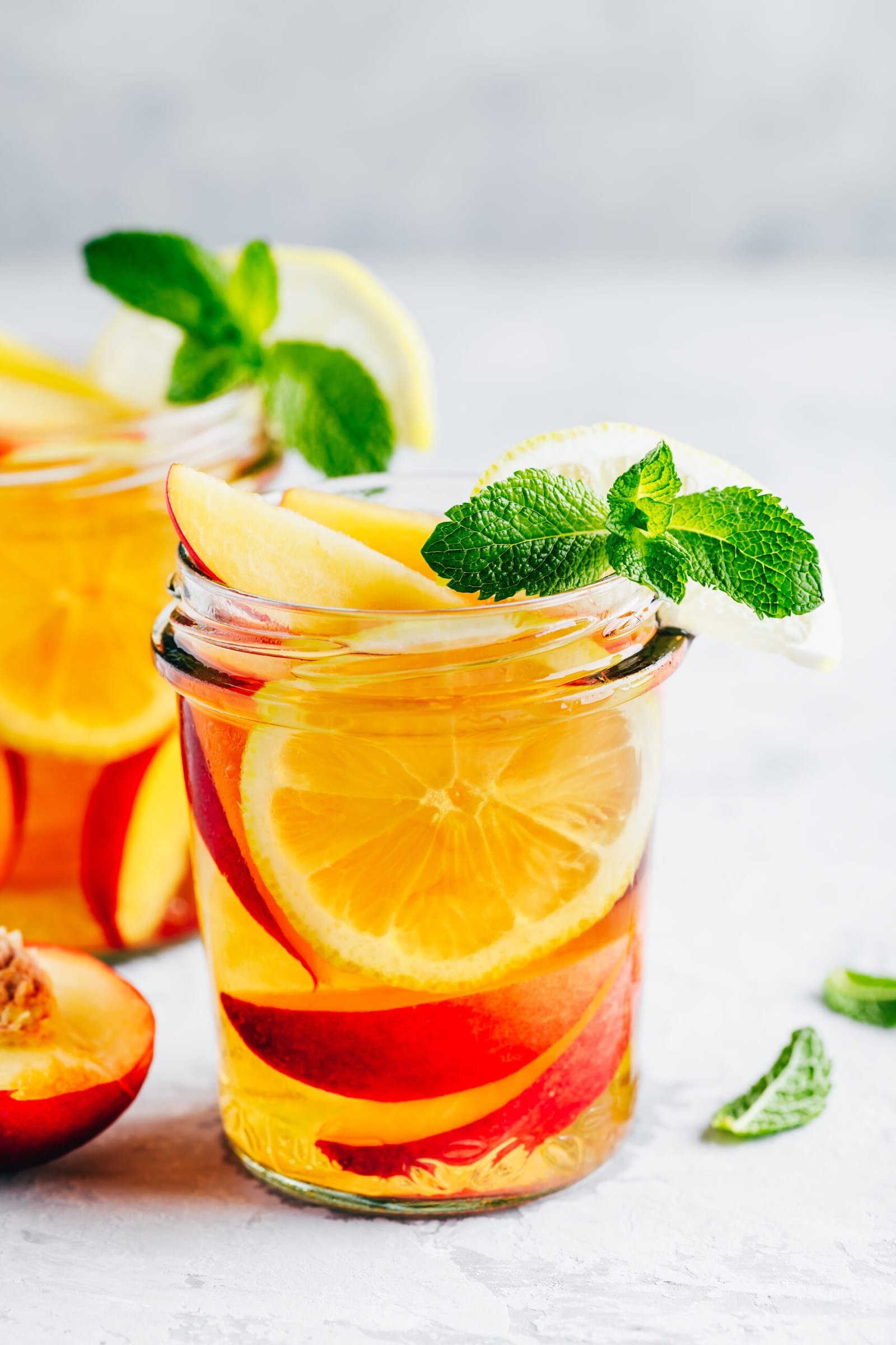 Cold peach and lemon iced tea. Summer refreshing drink with peach, lemon and ice.
