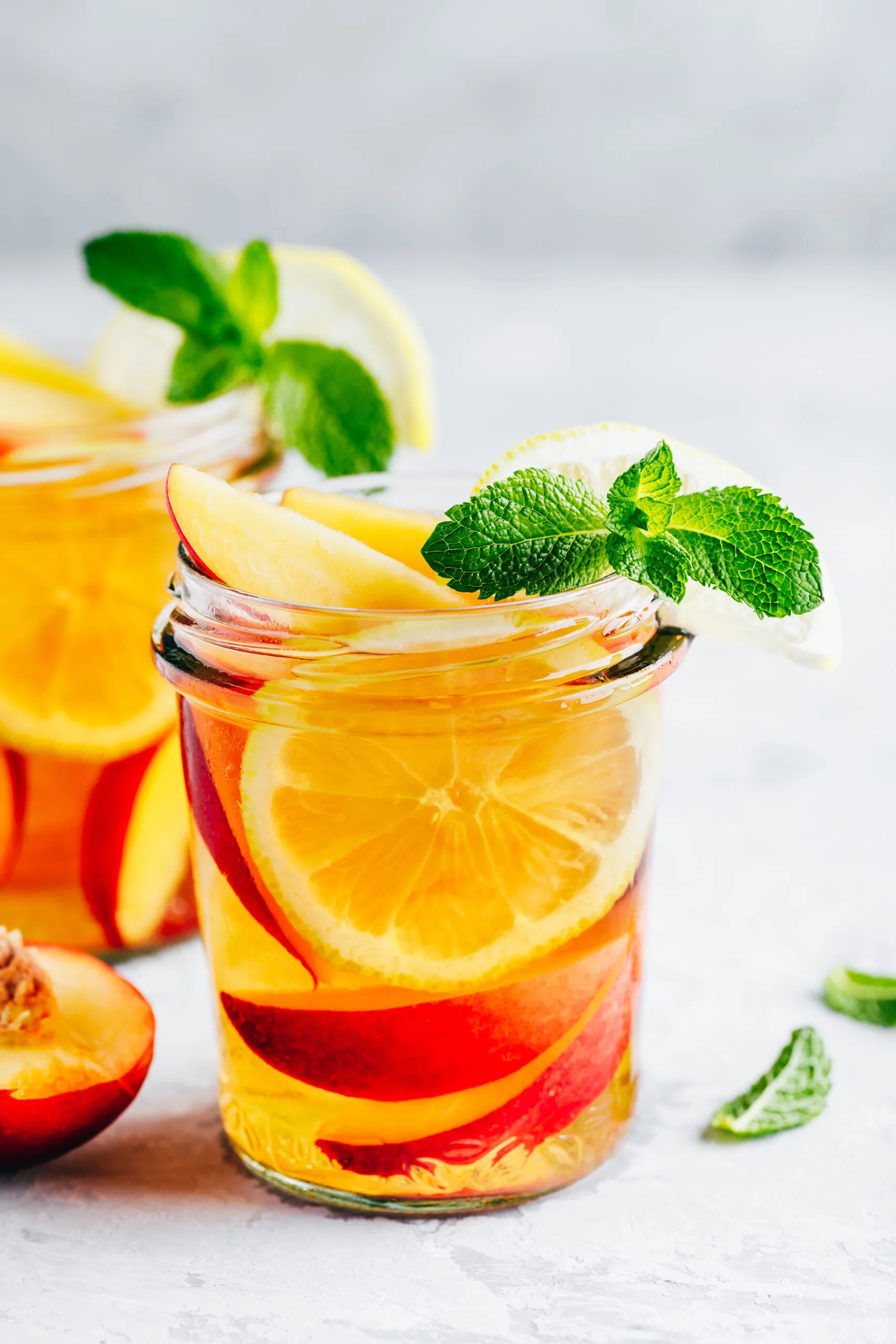 Cold peach and lemon iced tea. Summer refreshing drink with peach, lemon and ice.