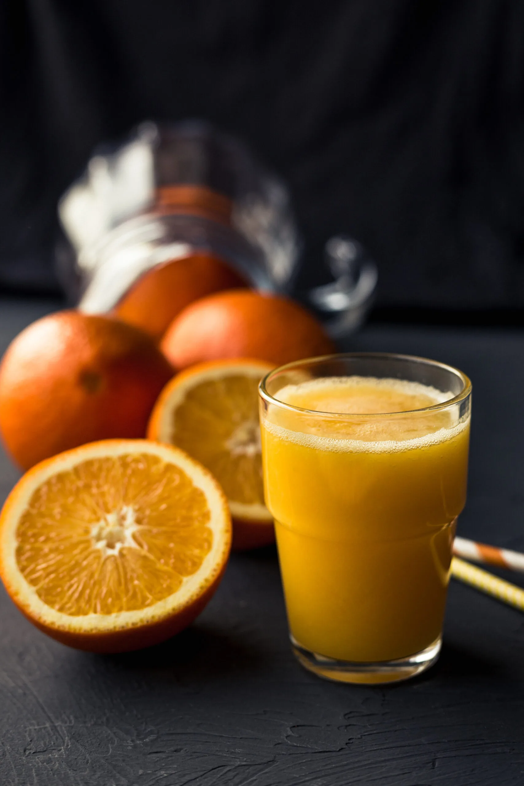 Fresh orange juice and fresh fruit oranges on a black background