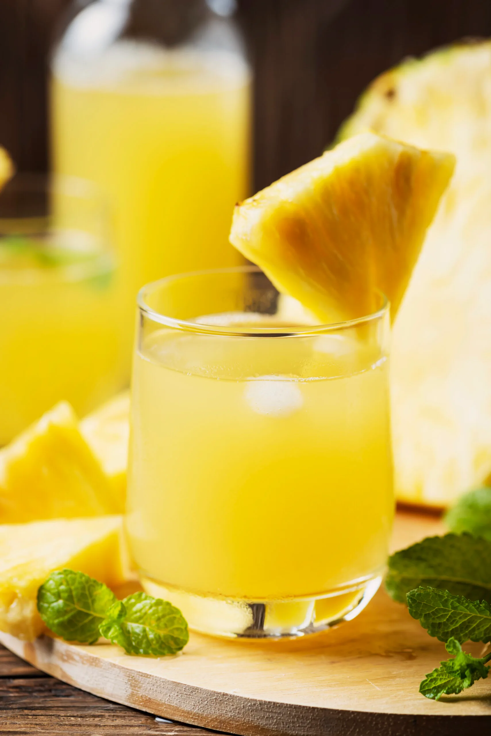 Fresh summer pineapple juice on the rustic wooden table, selective focus image